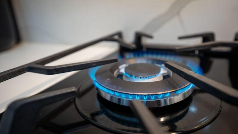 A close-up of a lit gas stove burner, showcasing the precision and safety ensured through expert gas fitting services.